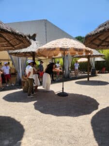 Groupe jouant à la pétanque sous des parasols en paille lors d'un événement ensoleillé à Toulouse.